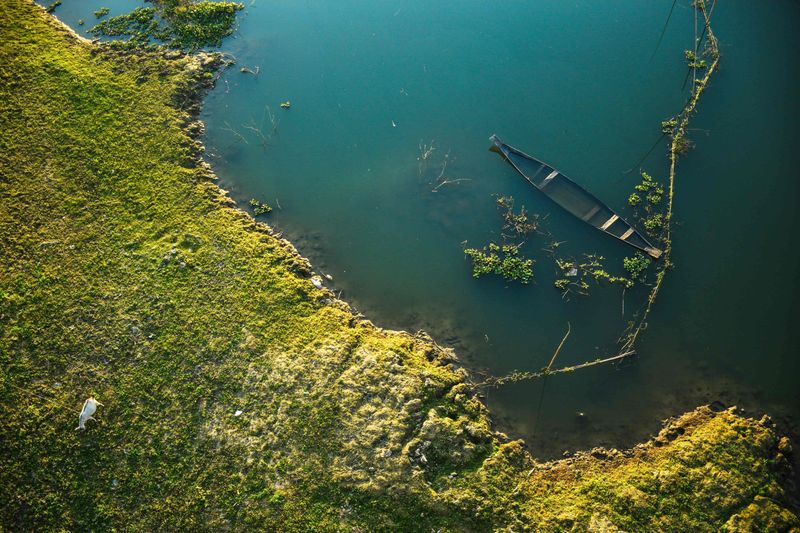 Boat on a misty river — photograph by Ajmain Fayek